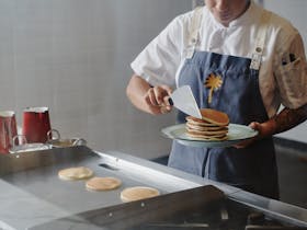 Chef cooking pancakes and serving them on a plate