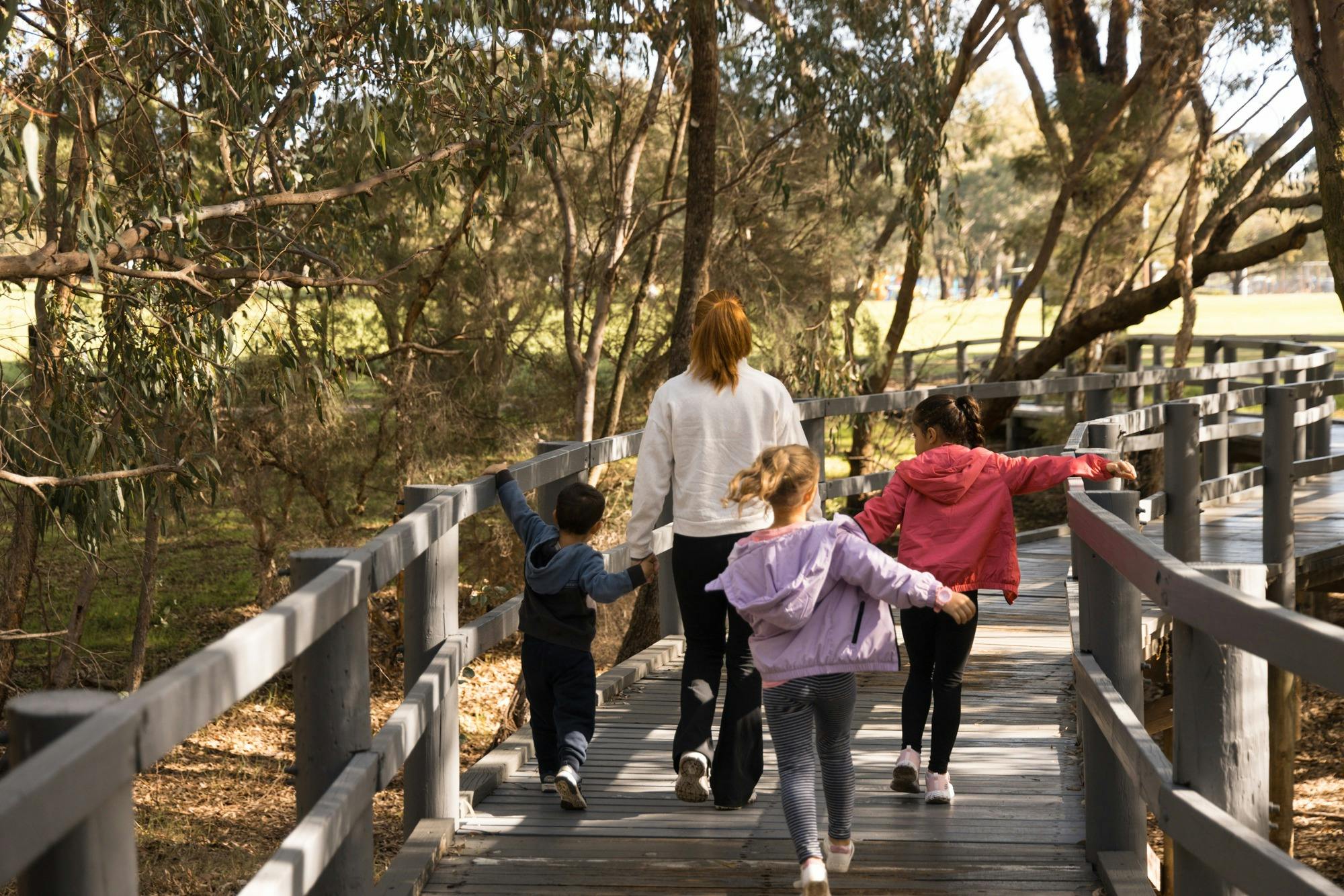 Family running along the boardwalk at Lake Gwleup