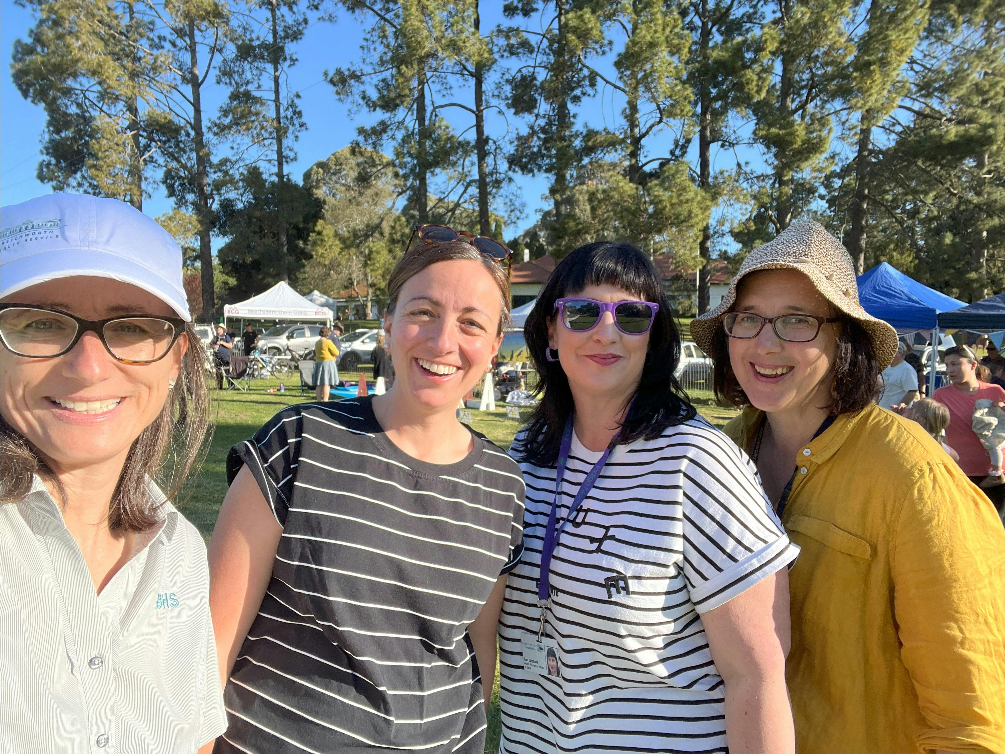 four women stand and smile at camera