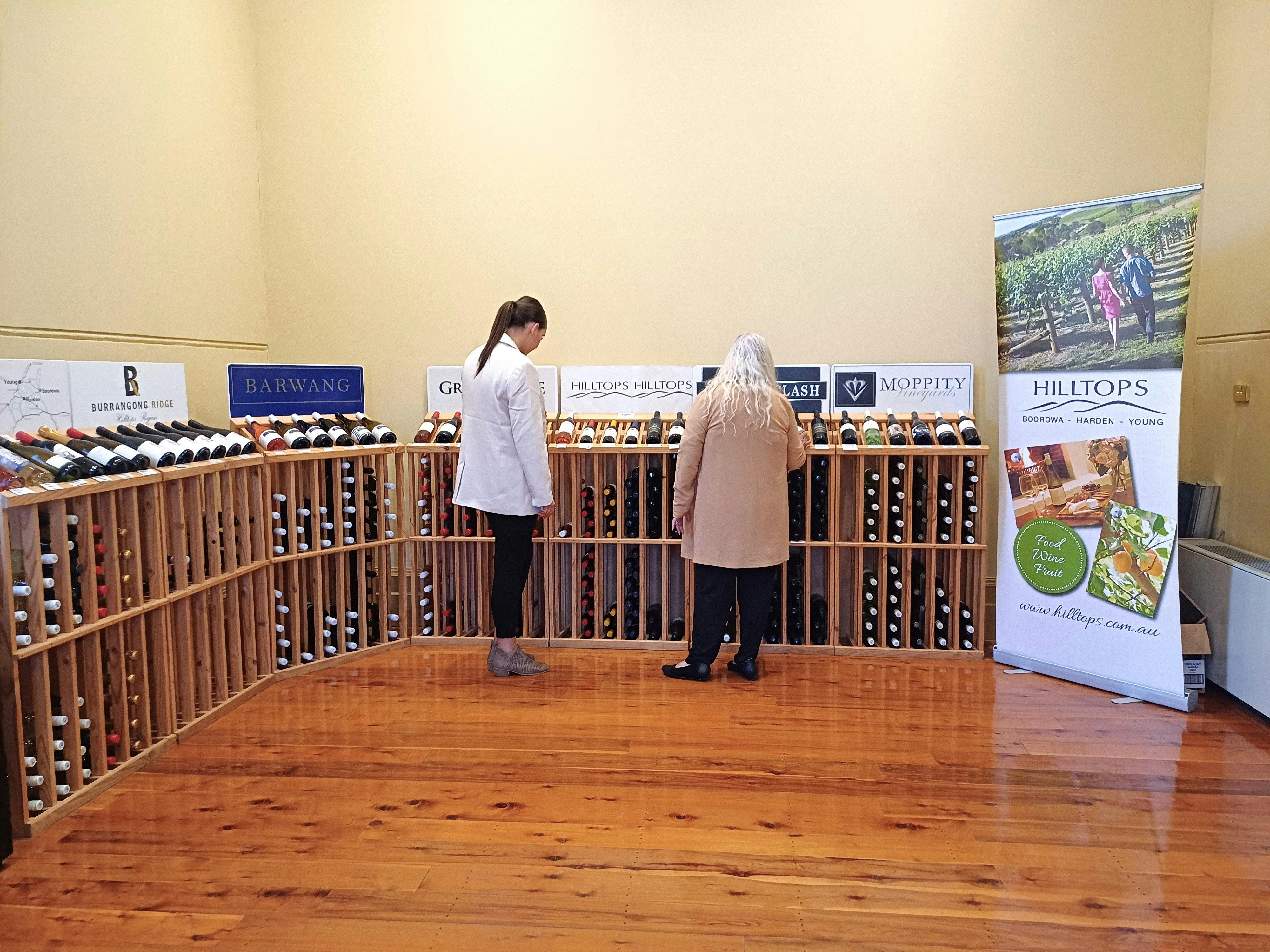 Two women browsing Hilltops Wines in a beautiful big room.