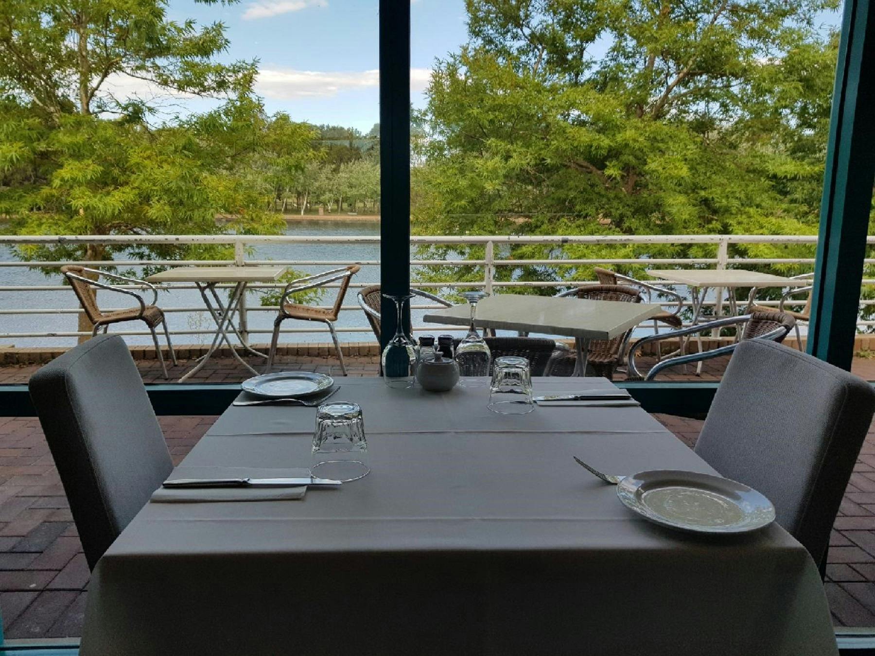 Empty table setting next to window overlooking lake