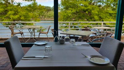 Empty table setting next to window overlooking lake