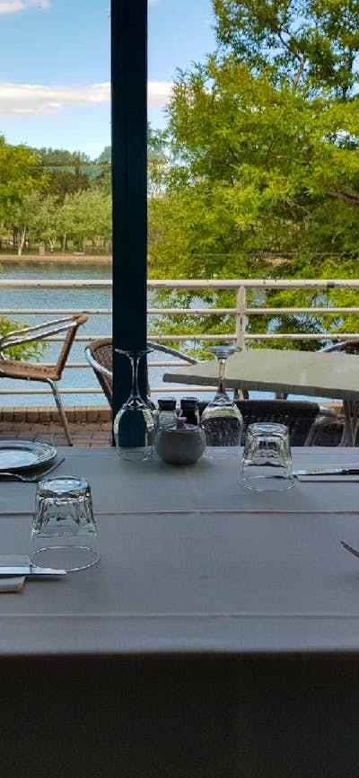 Empty table setting next to window overlooking lake