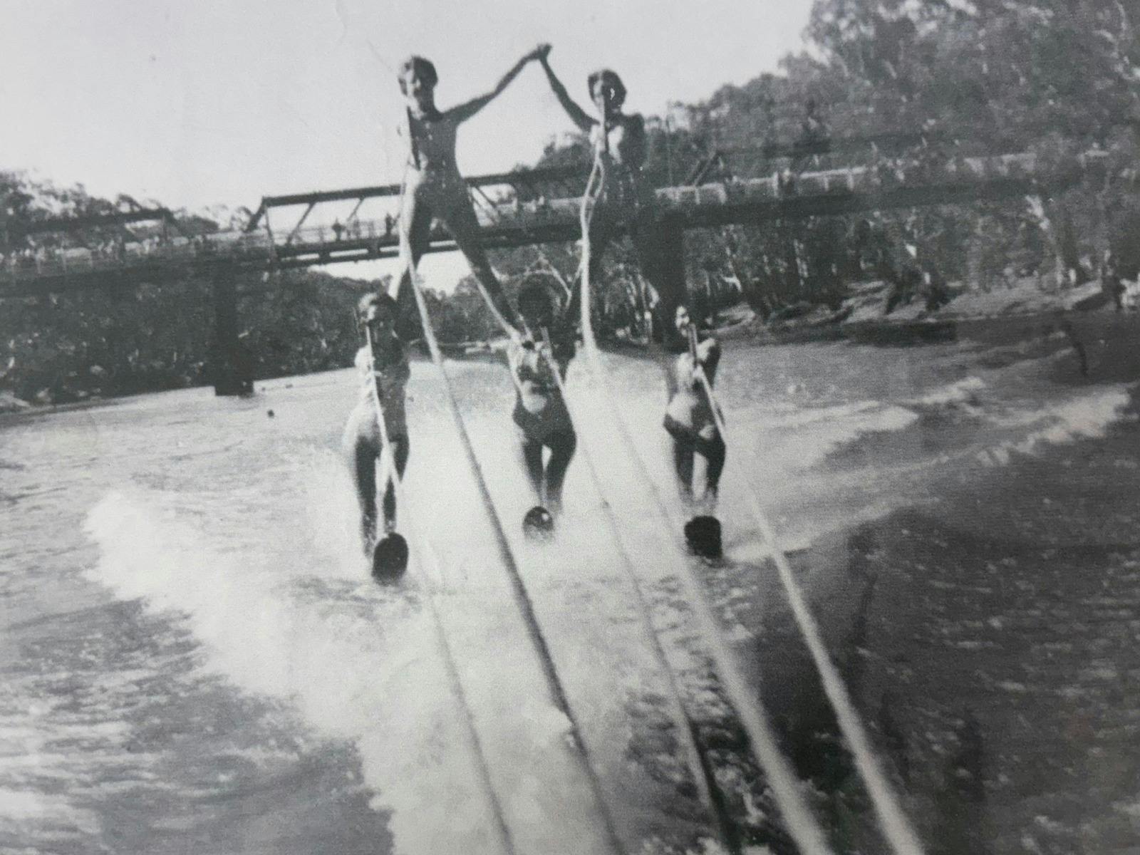 5 women on water skiis  form a pyramid