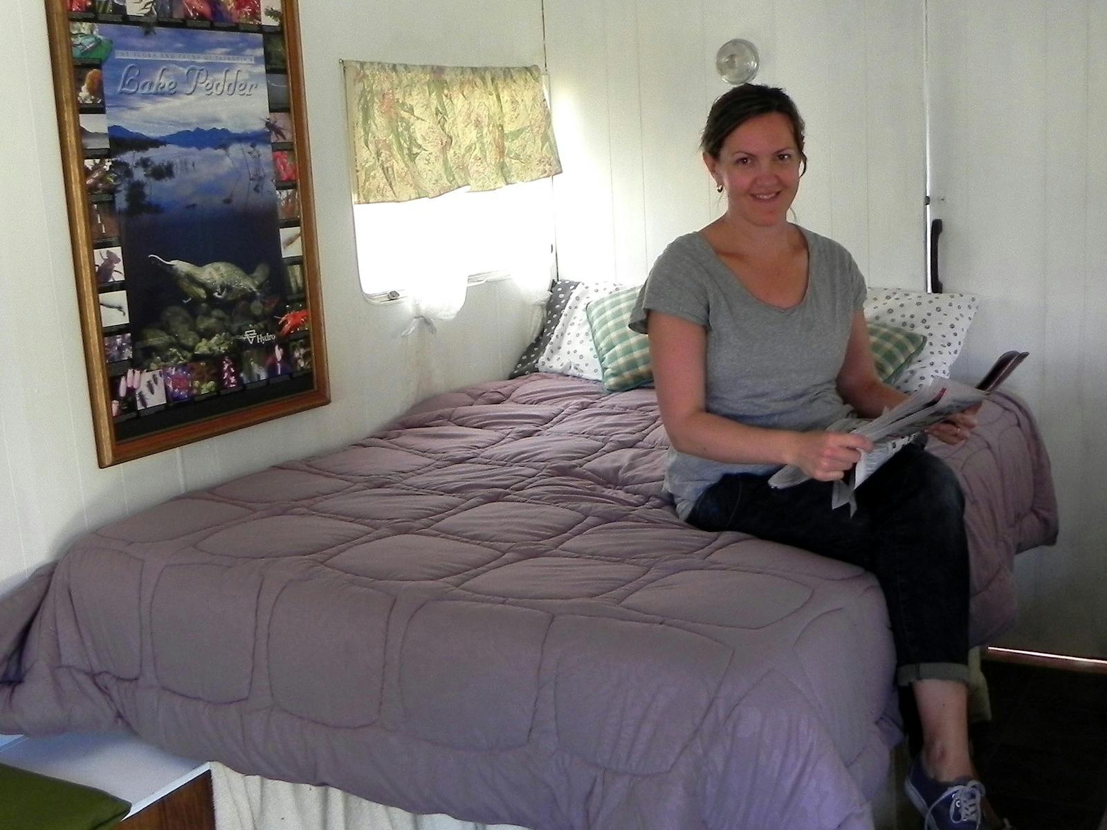 Girl sitting on bed in Platypus Cabin