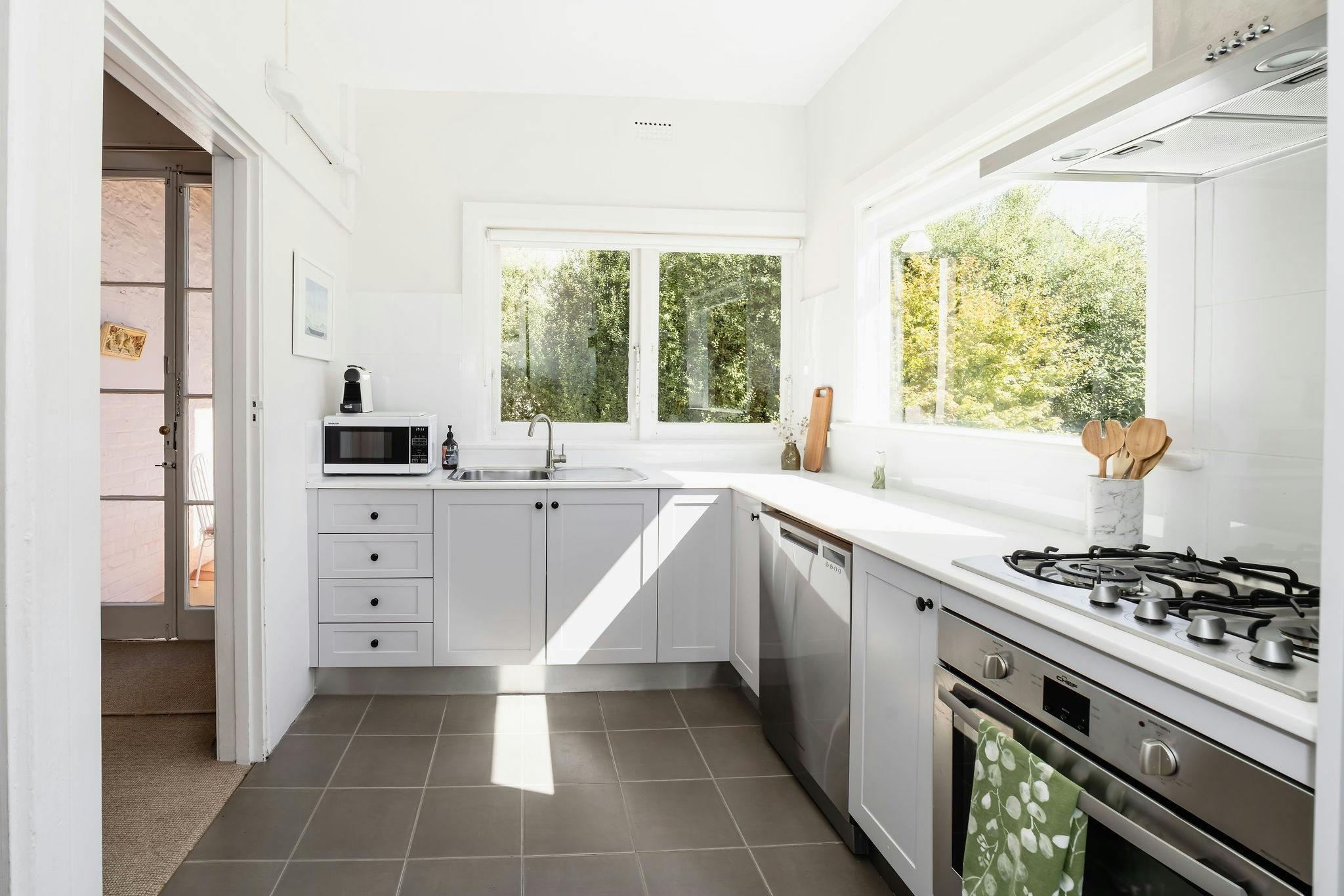 A sun streamed kitchen at Maison Del Mar showing the garden view from the window