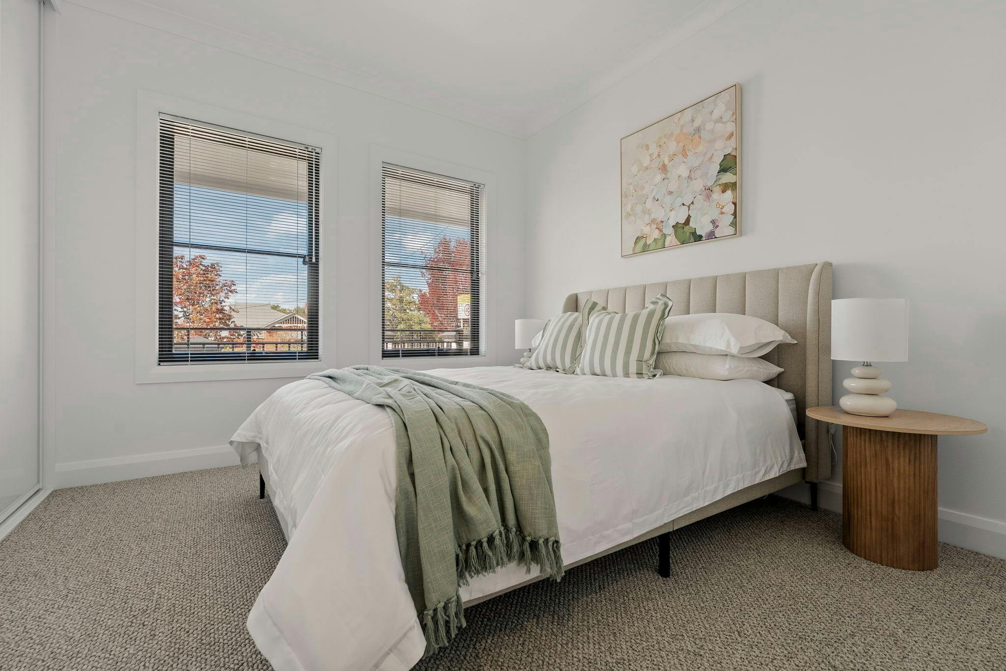 Bedroom with queen bed, white bedding and green features