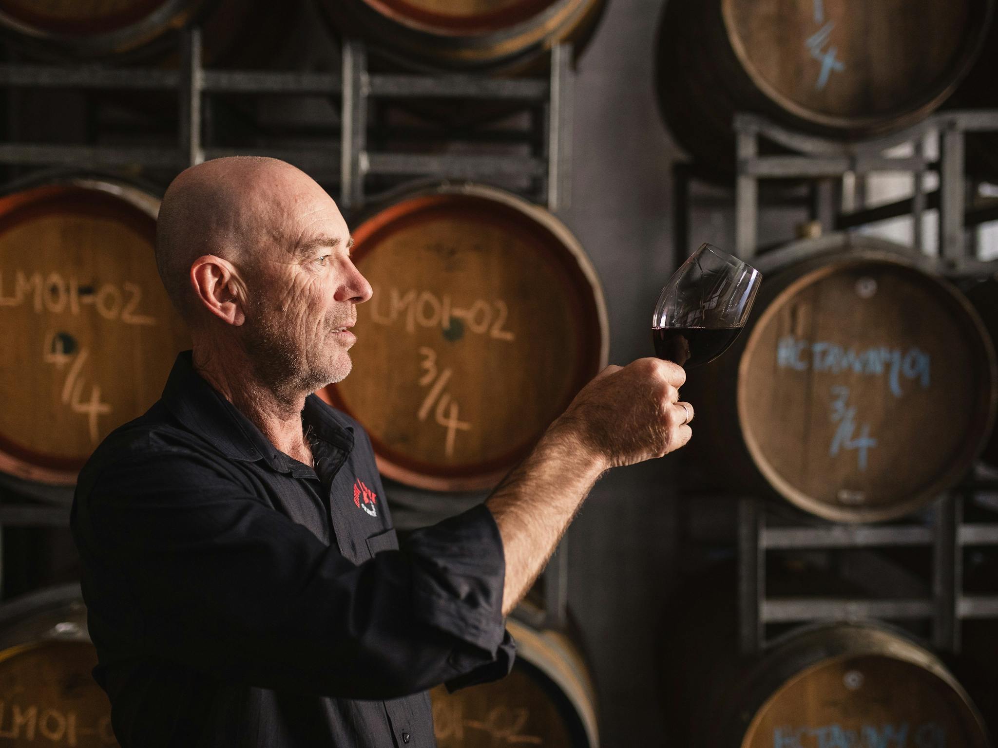 Winemaker Andy Williams swirls a fresh barrel sample in a glass in the Barrel Room