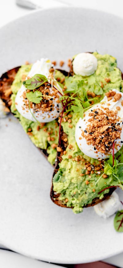 Smashed avocado & goats curd w/ poached eggs & dukkha on grilled rye toast (v, gf*, df*)