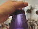 Hand holding flask of violet coloured liquid