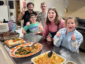 Participants with the camp chef in the kitchen after preparing healthy meals ready to enjoy together