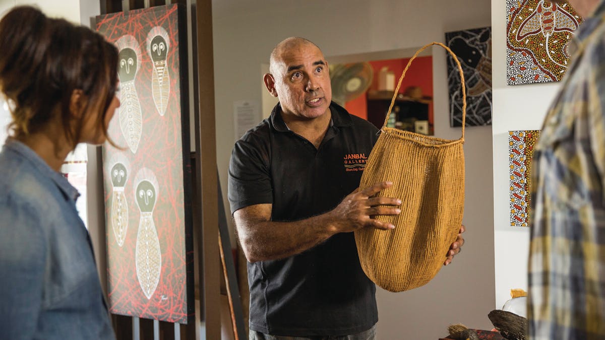 Artist teaching customers about traditional basket weaving methods