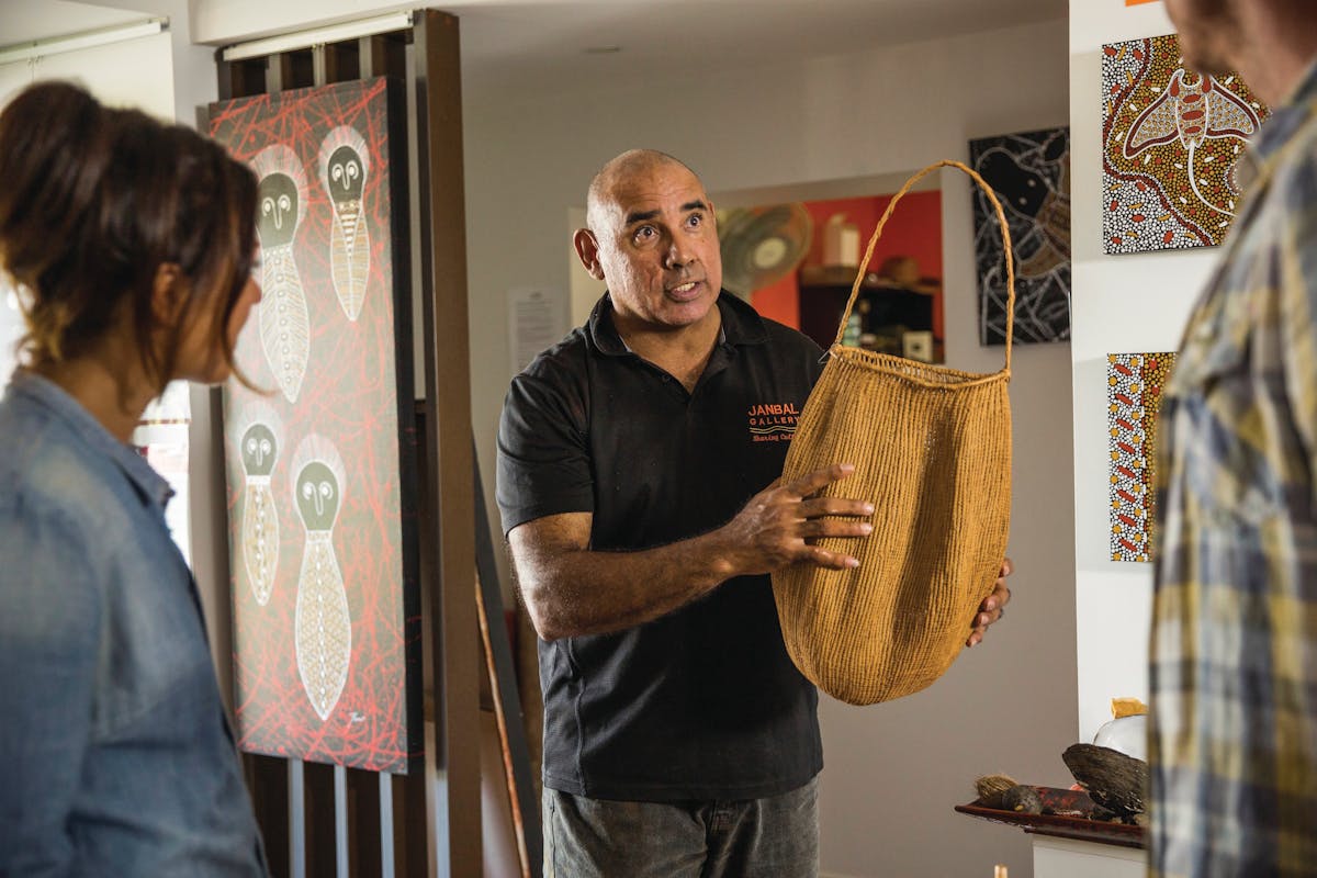 Artist teaching customers about traditional basket weaving methods