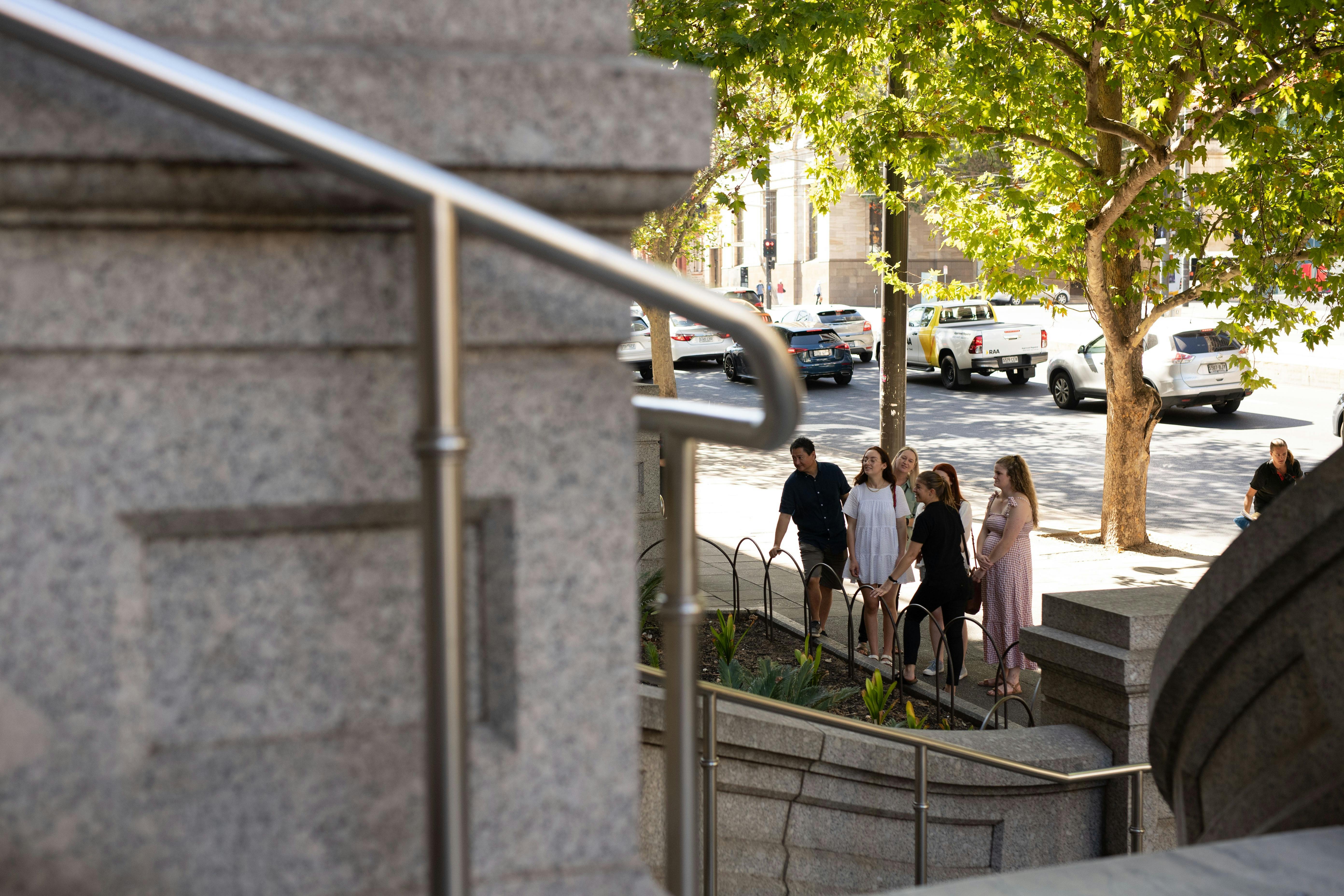 A tour group looks toward features of Adelaide's Parliament House while on tour.