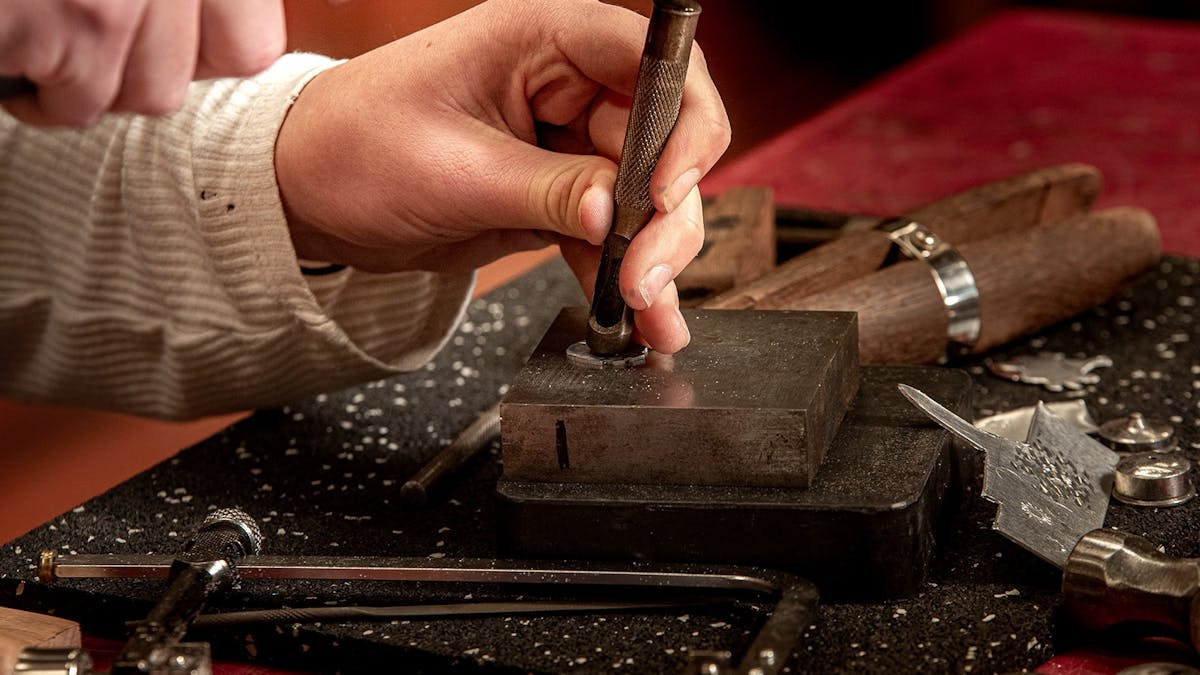 Person using metalcraft tools to create a piece of the ring jewellery.