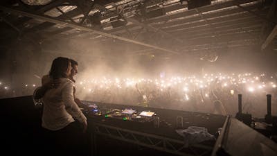Large dance floor with hundreds of torches waving to the DJs