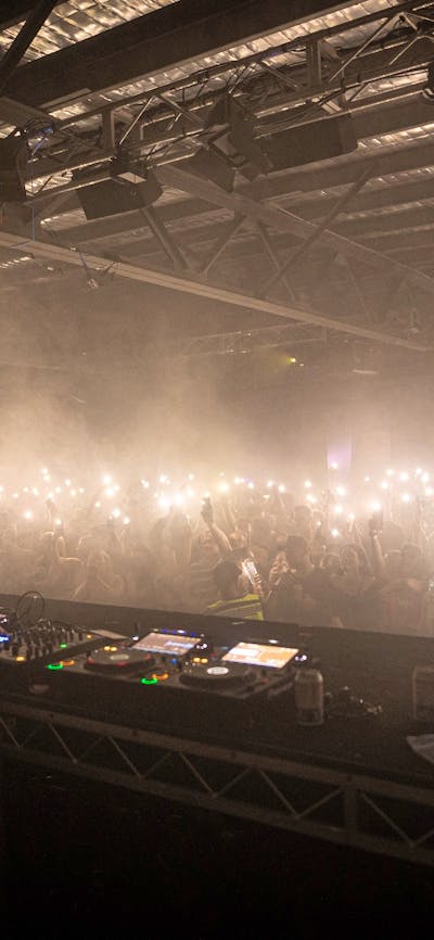 Large dance floor with hundreds of torches waving to the DJs