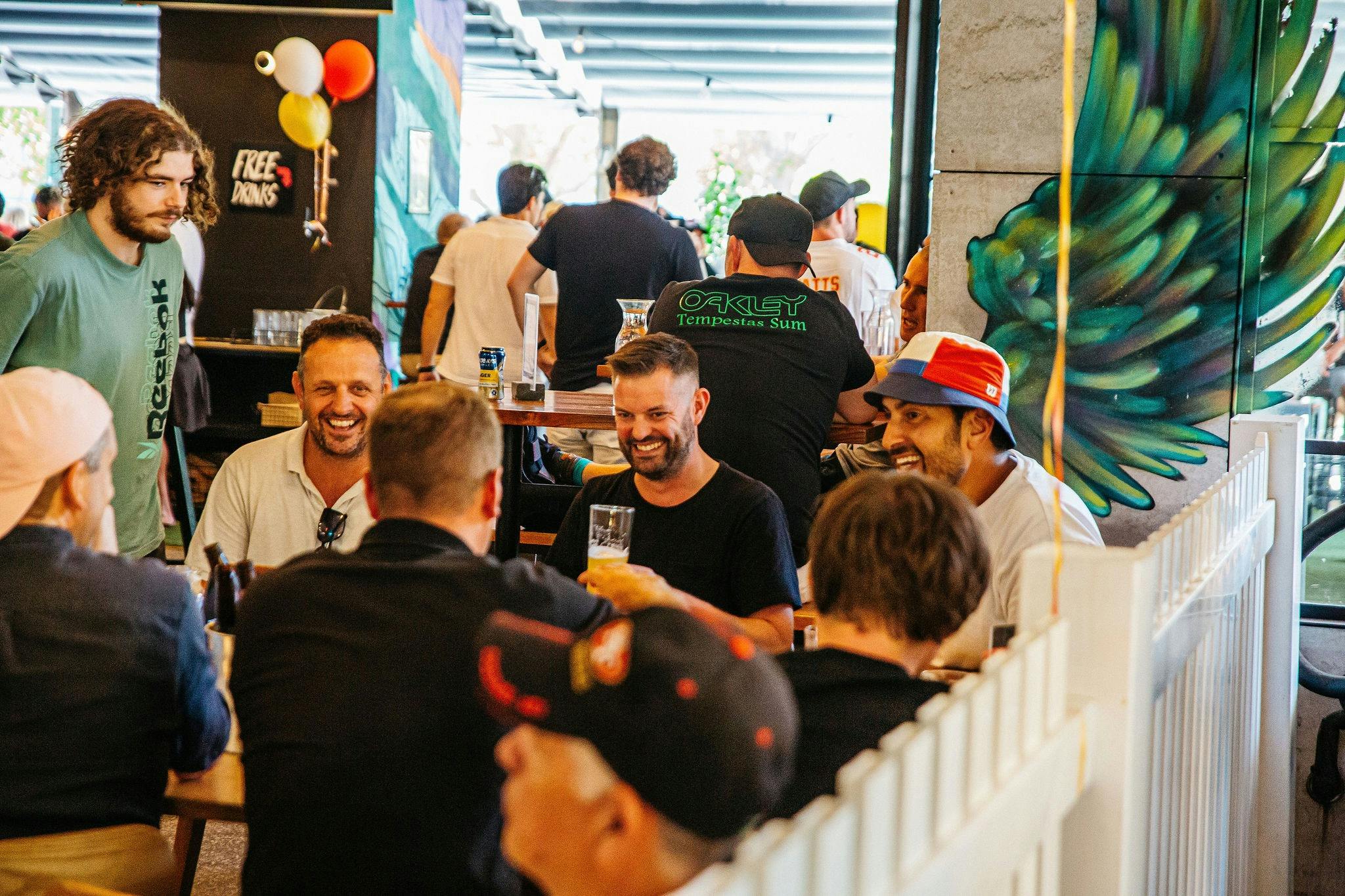 A group of male friends enjoy a laugh and some beverages