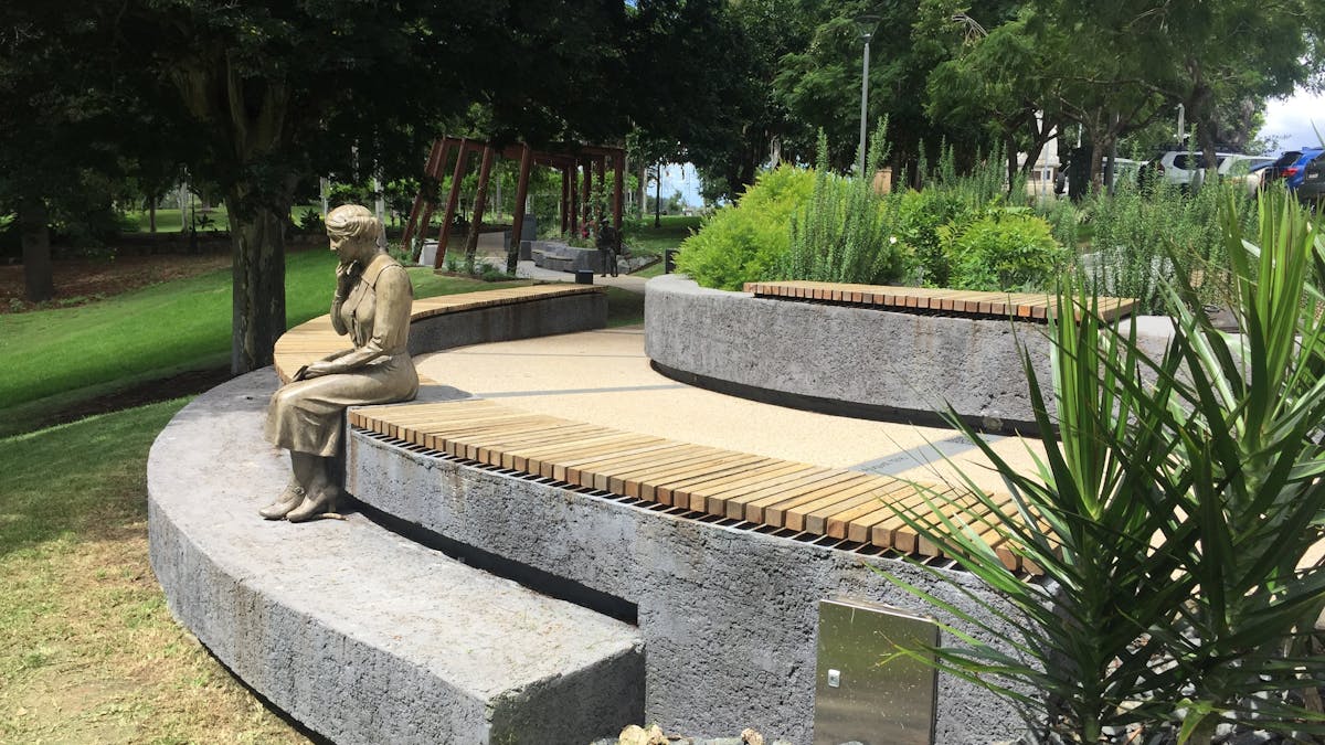 photo showing statue of a woman sitting and staring out to the park after reading mail