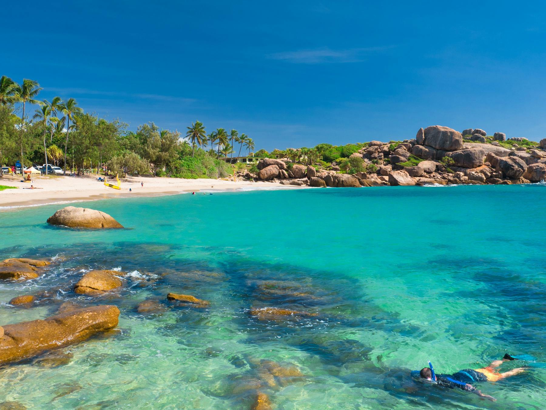 Person snorkeling at sandy beach