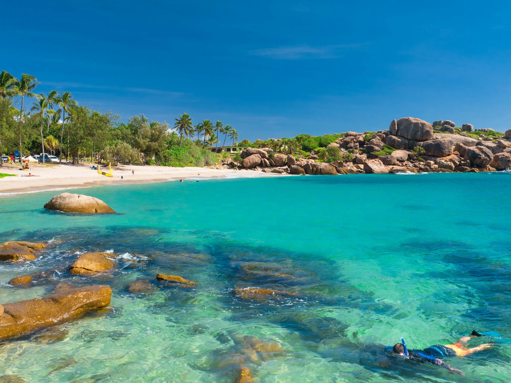 Person snorkeling at sandy beach