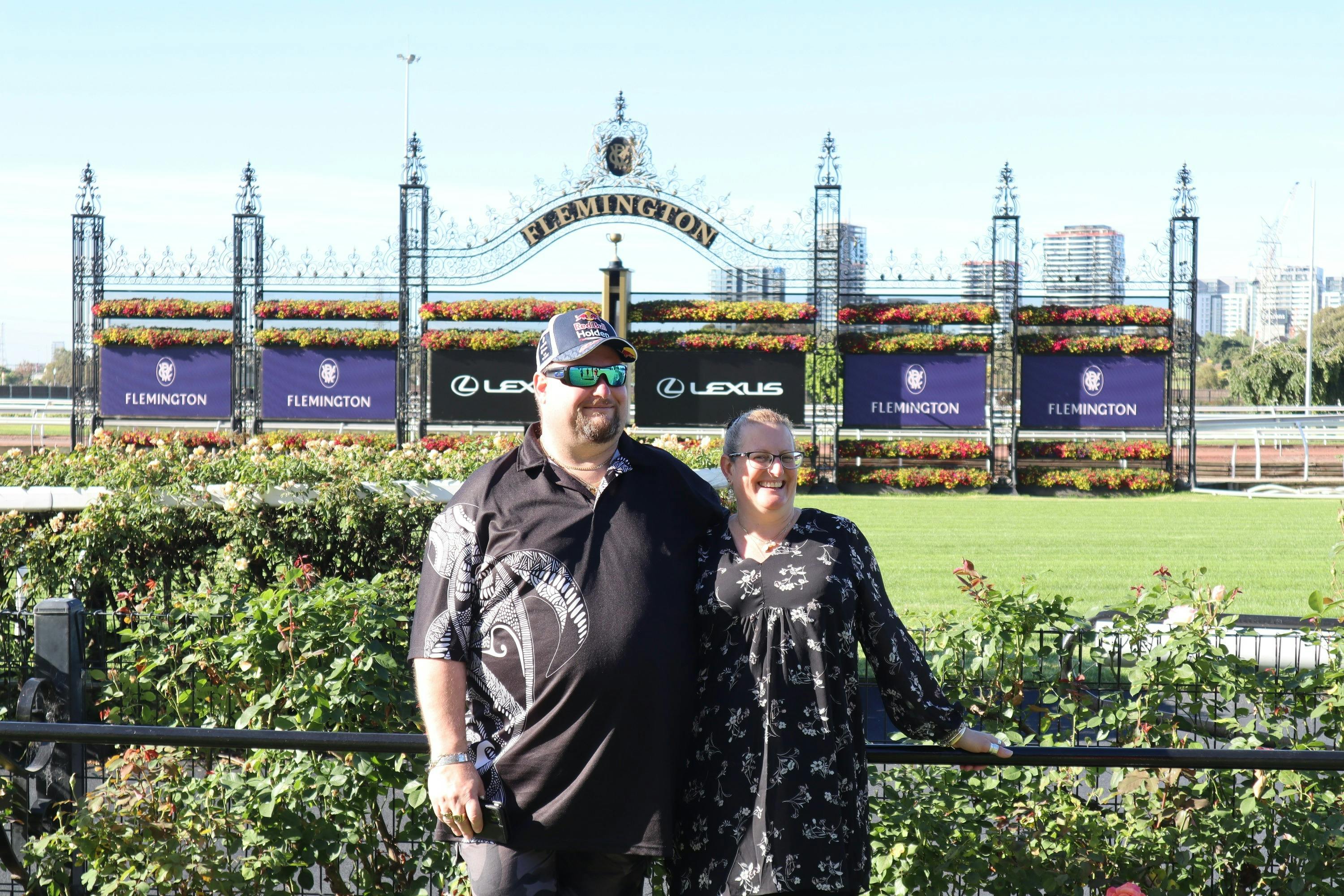 Guests standing in front of the Flemington racecourse finishing line
