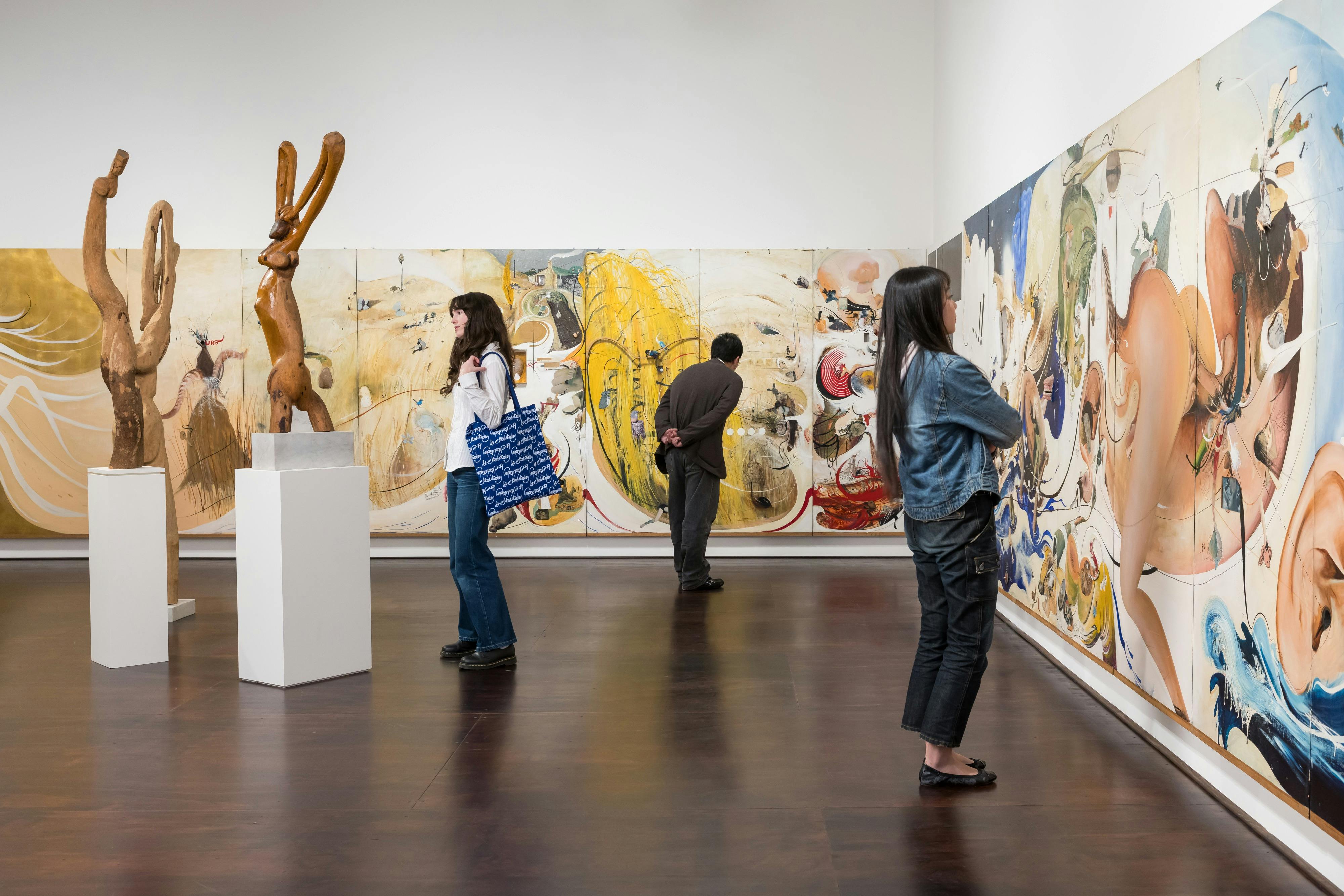 a man and two women peruse Brett Whiteley's works in a gallery space