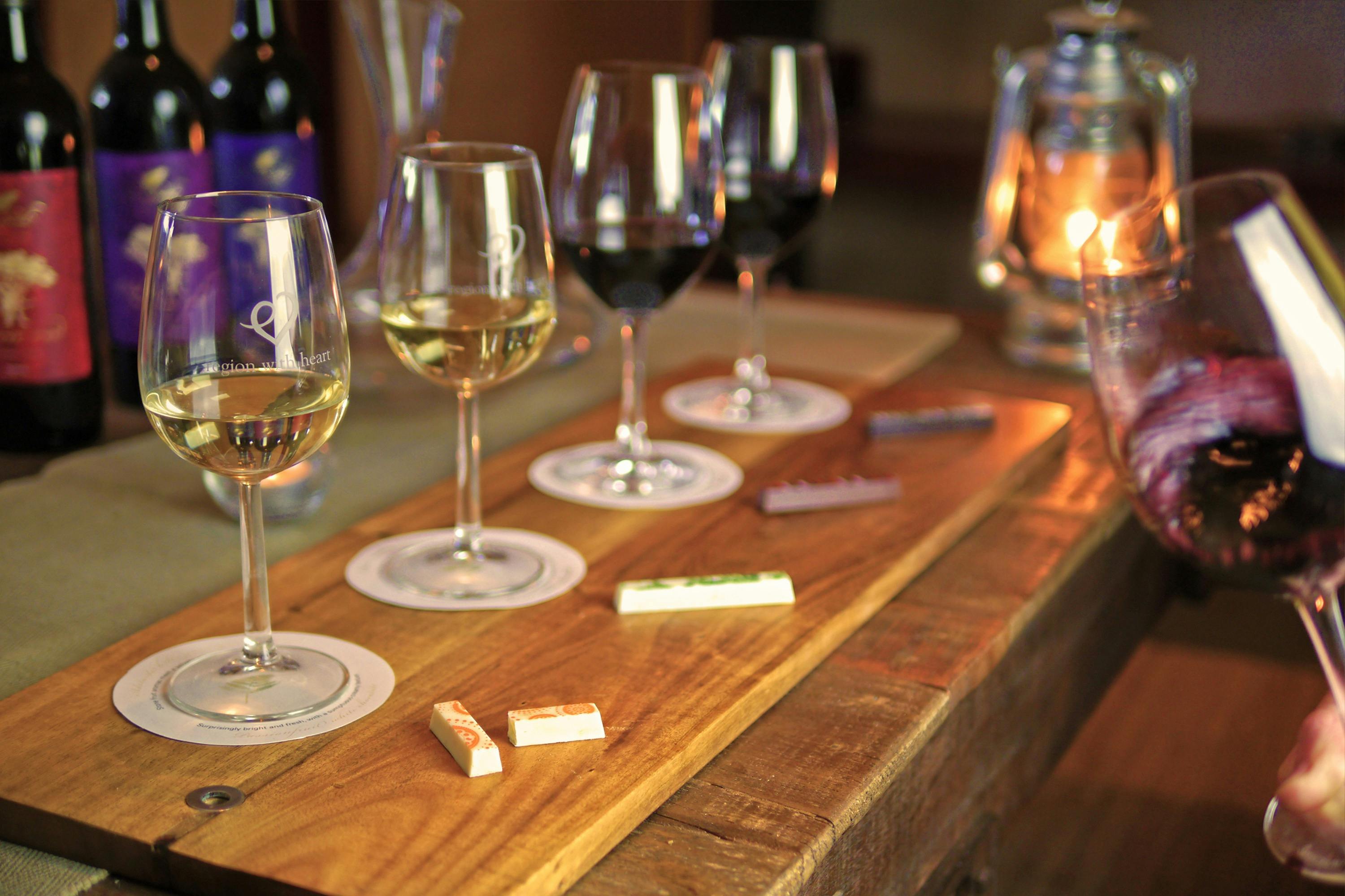 Wine glasses on a table with chocolate bars in front of each glass