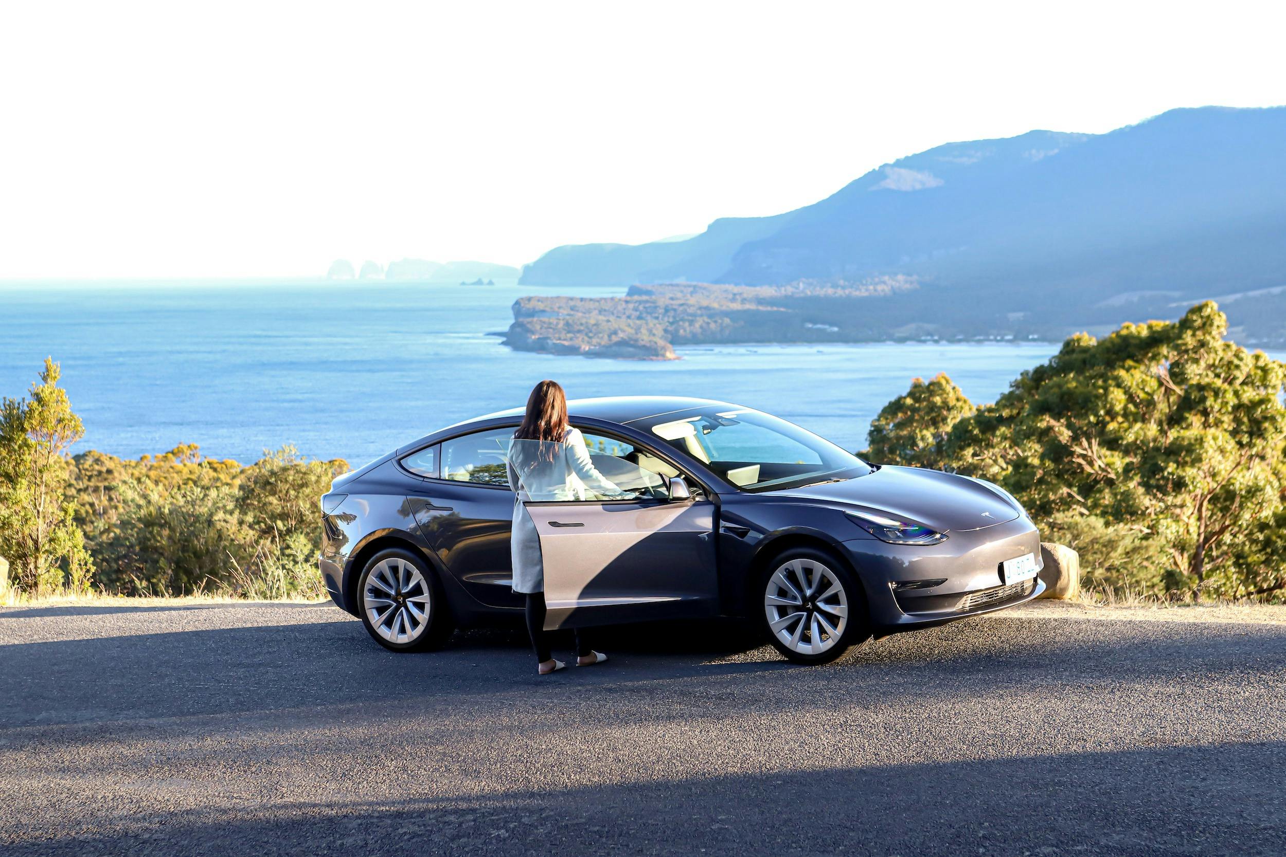 A lady beside her car, look out over the Tasman Peninsula