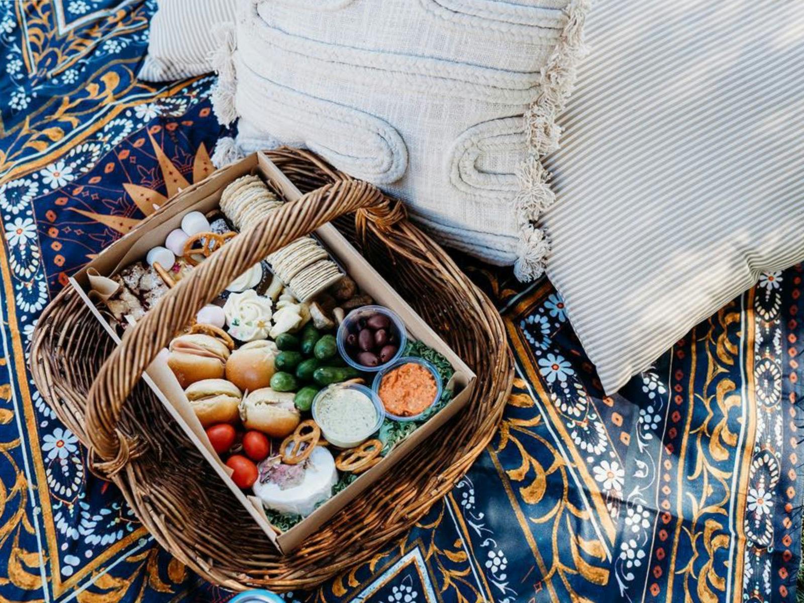 Select of picnic goods inside a wicker basket with drinks