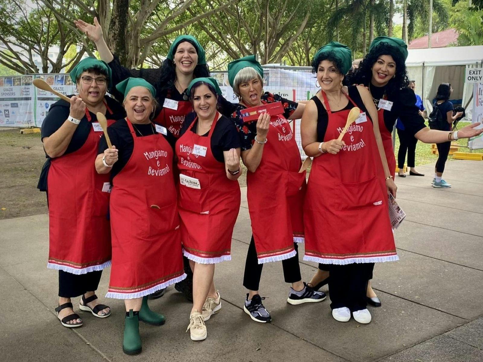 Comedy Tours Italian Mammas in their signature "mangiamo e beviamo" aprons posing at La Festa