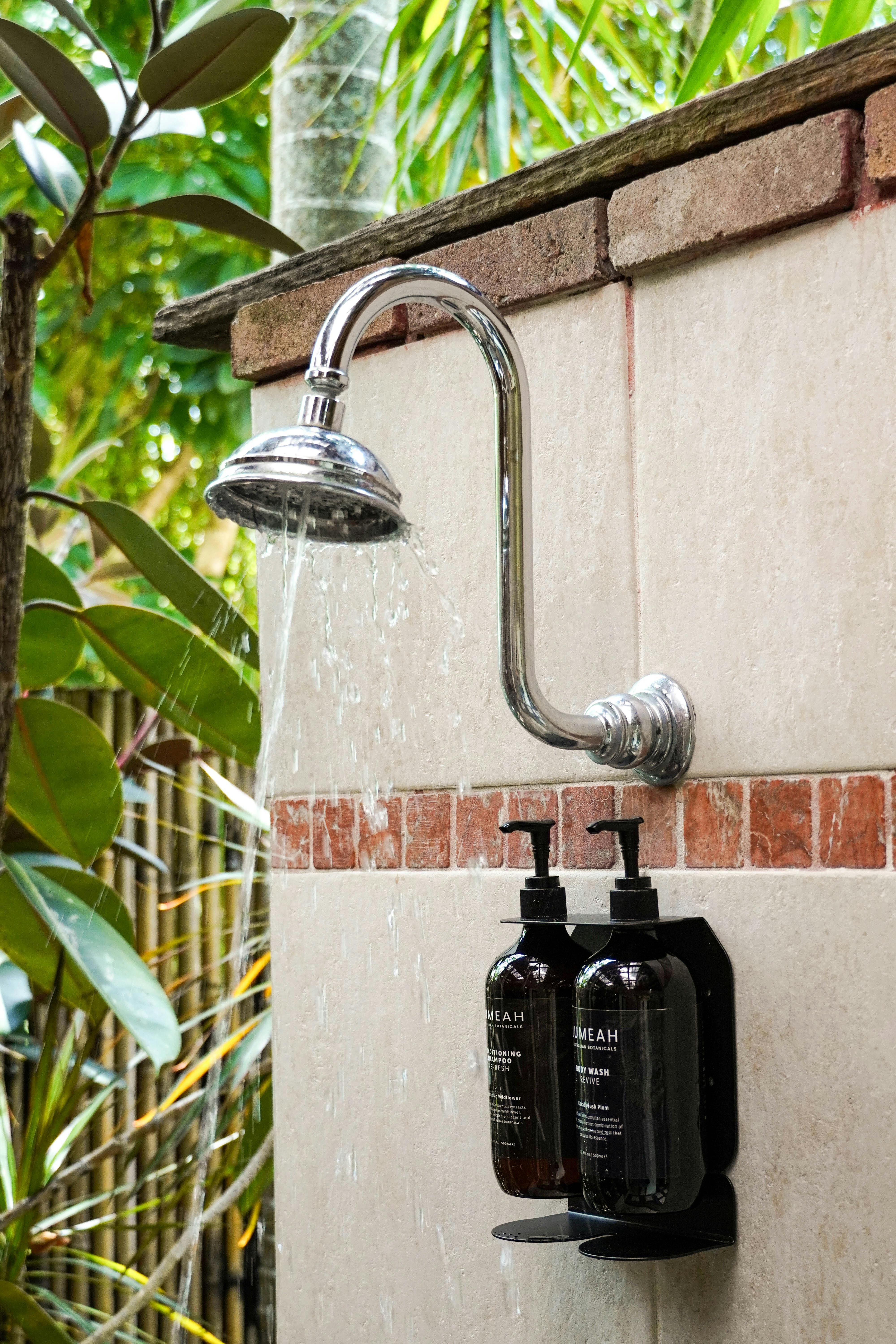 Outdoor rain shower surrounded by tropical greenery at Dragonfly's Rest Byron Bay