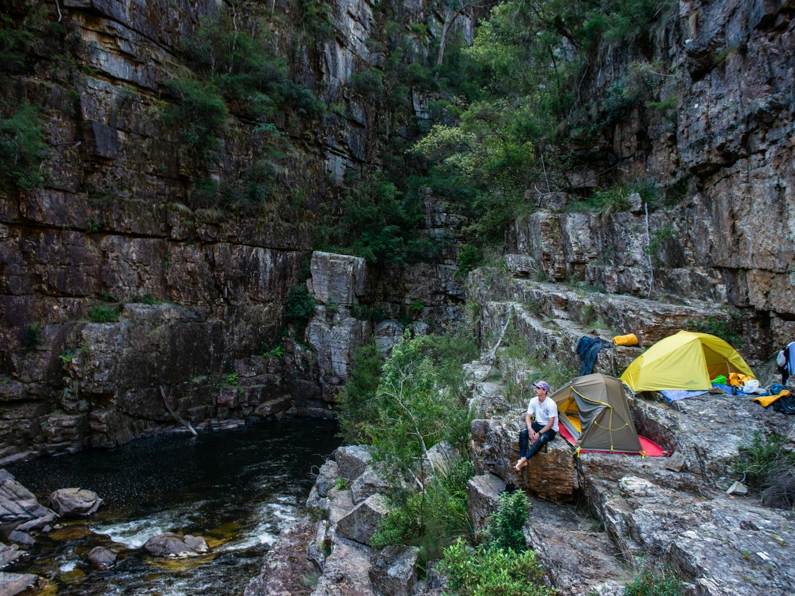 A tent set up in a stunning gorge campsite on a packrafting trip