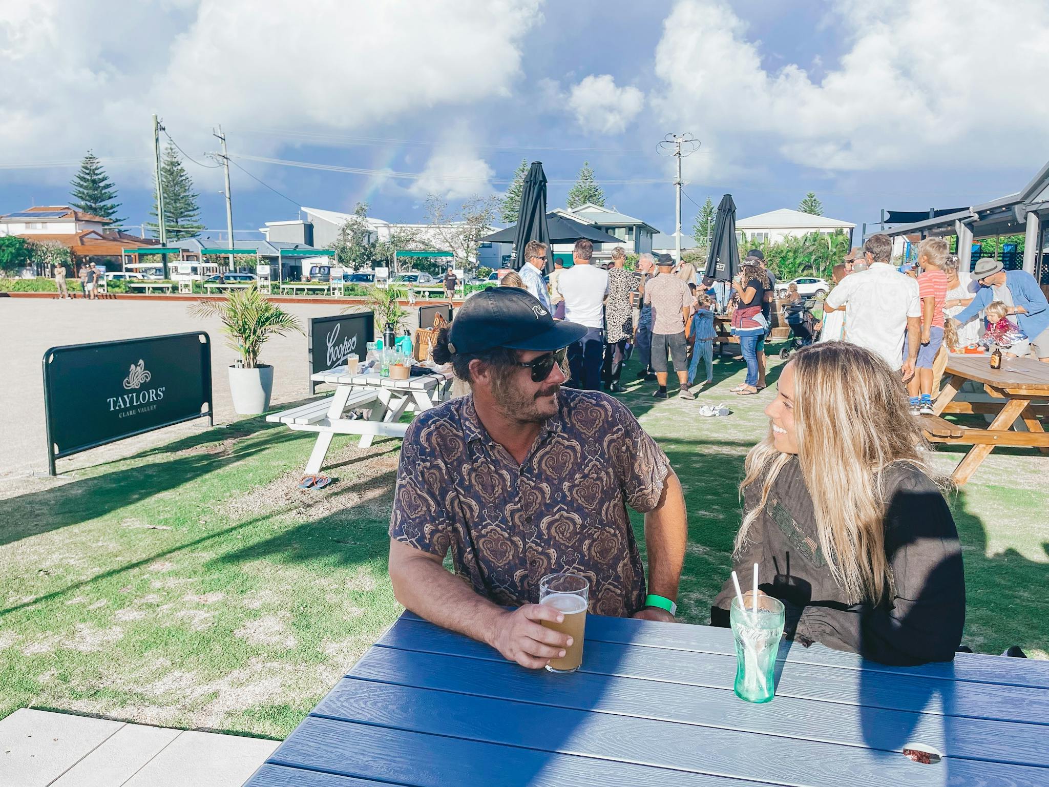 Image of two people gathered around a table with drinks on the lawns of Club Lennox