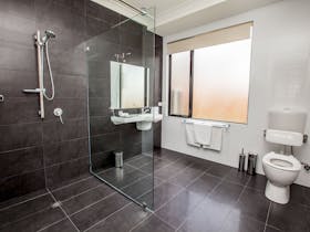 Disable friendly ensuite in villa 4 with large shower recess and raised toilet.