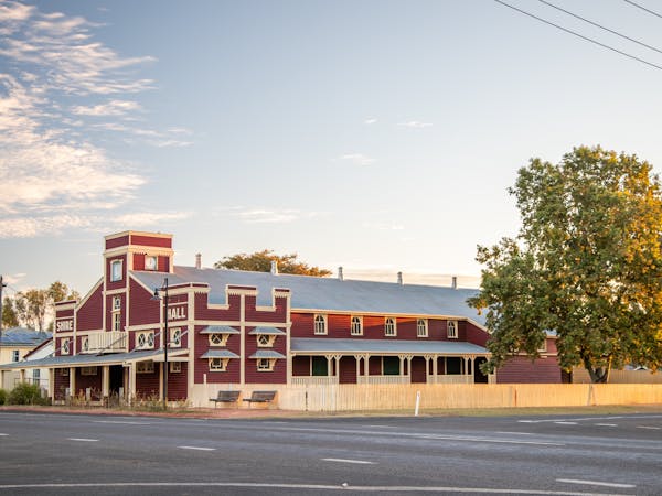 Exterior of the Surat Shire Hall, a large building painted dark red with white trim