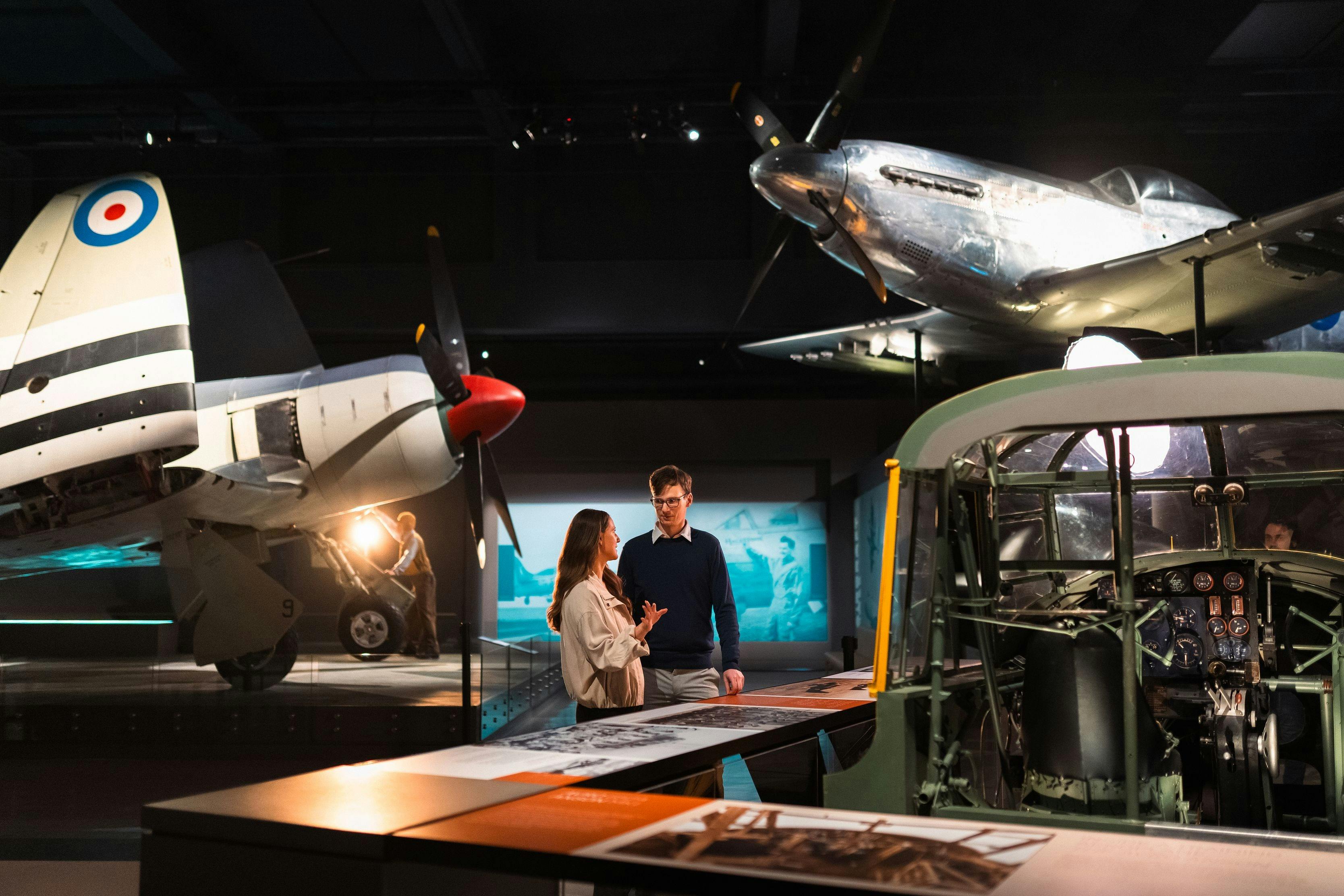 man and woman standing in galleries, surrounded by planes
