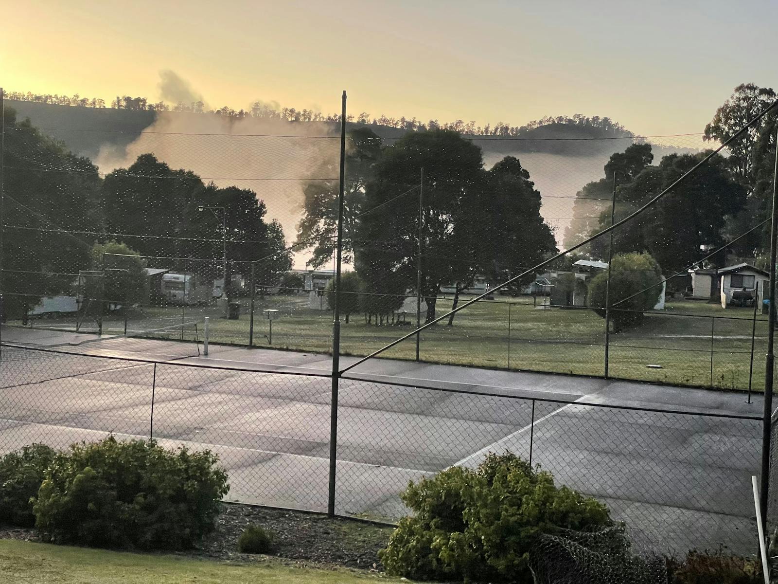 Tennis court and fog sitting over the lake