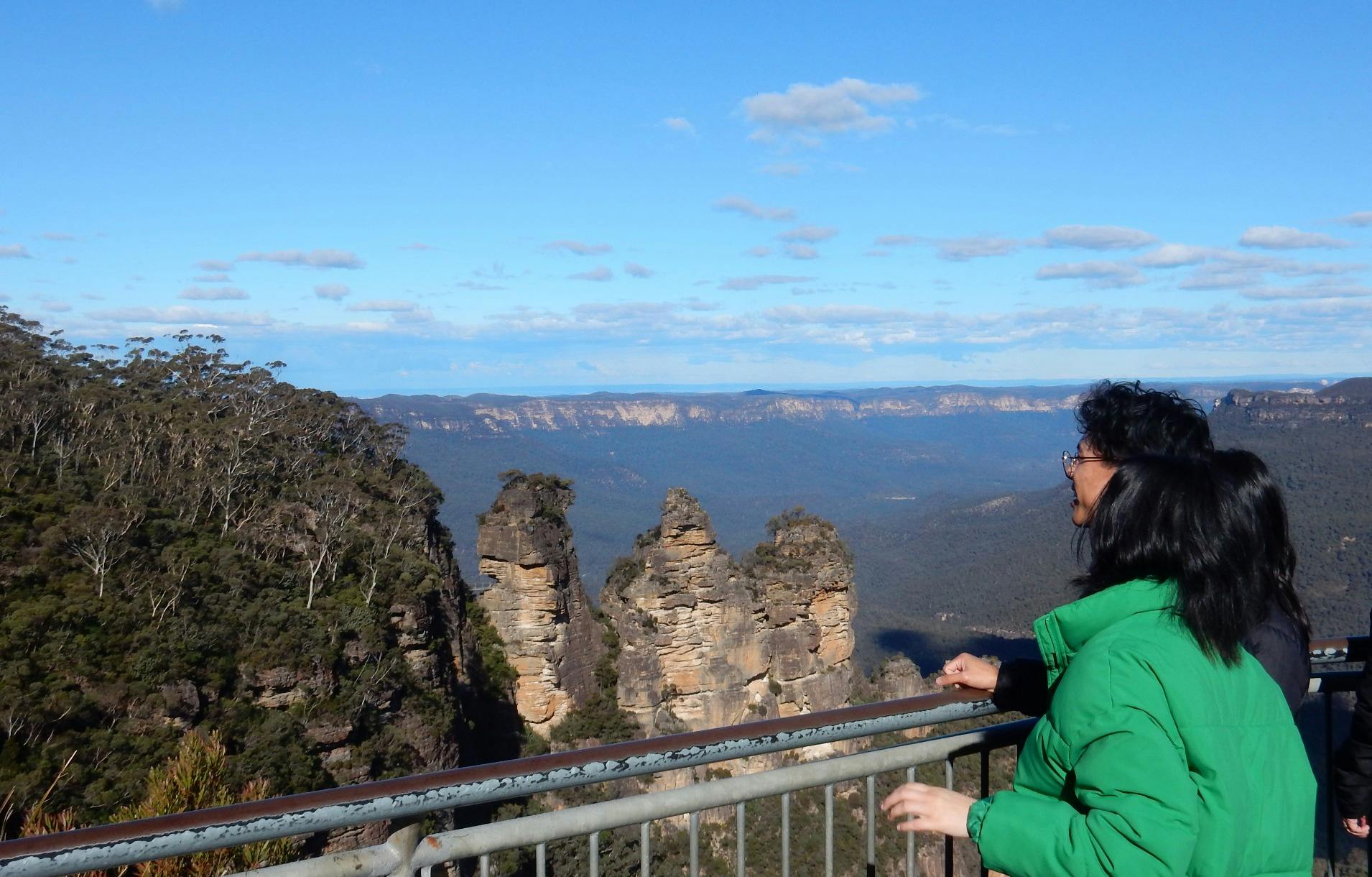 Visitors viewing Three Sisters rock formation from Echo Point lookout with Jamison Valley backdrop
