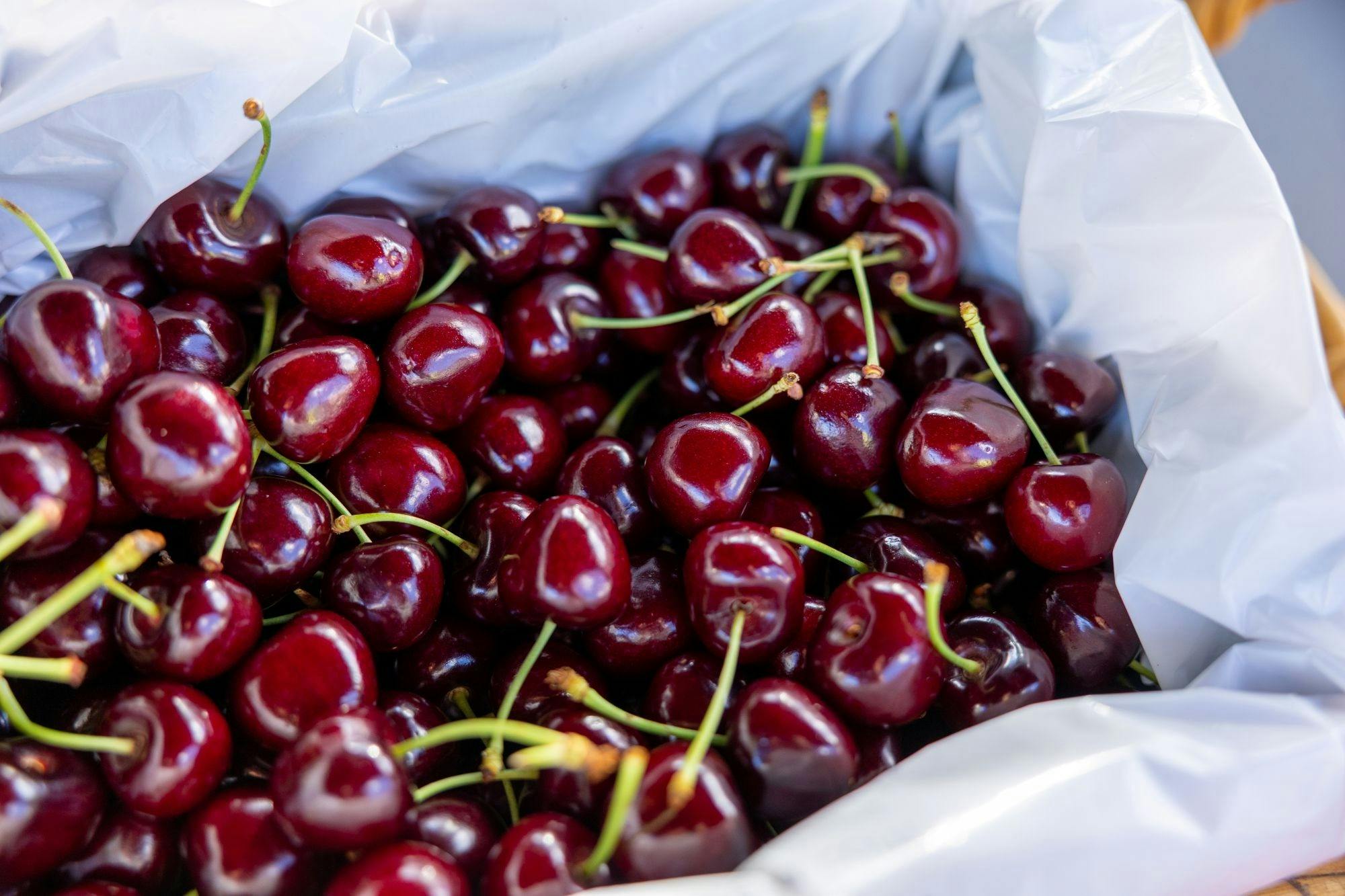 A box of dark red cherries, not a blemish in sight.