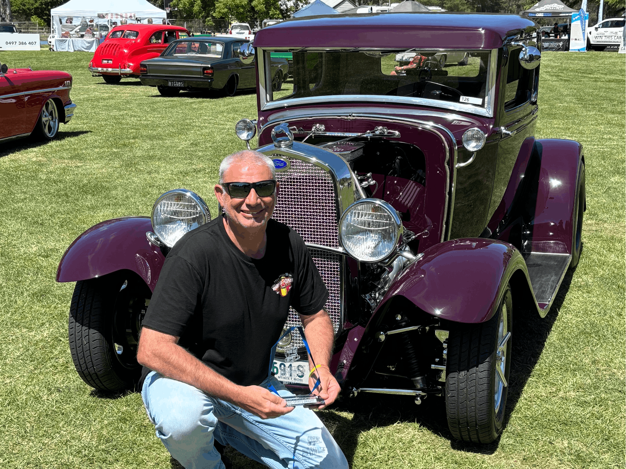 Man posing with a vintage car