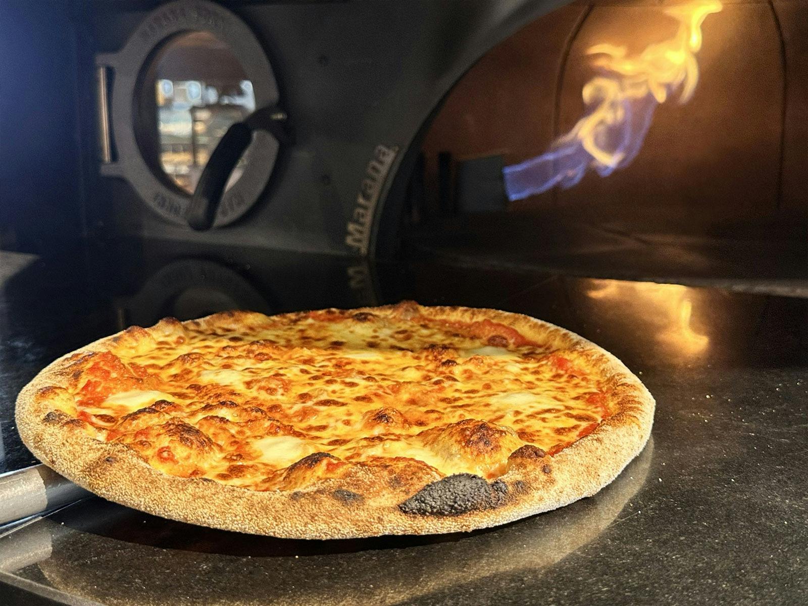 A pizza being taken out of the oven at Vasse Village by Bunbury Farmers Market