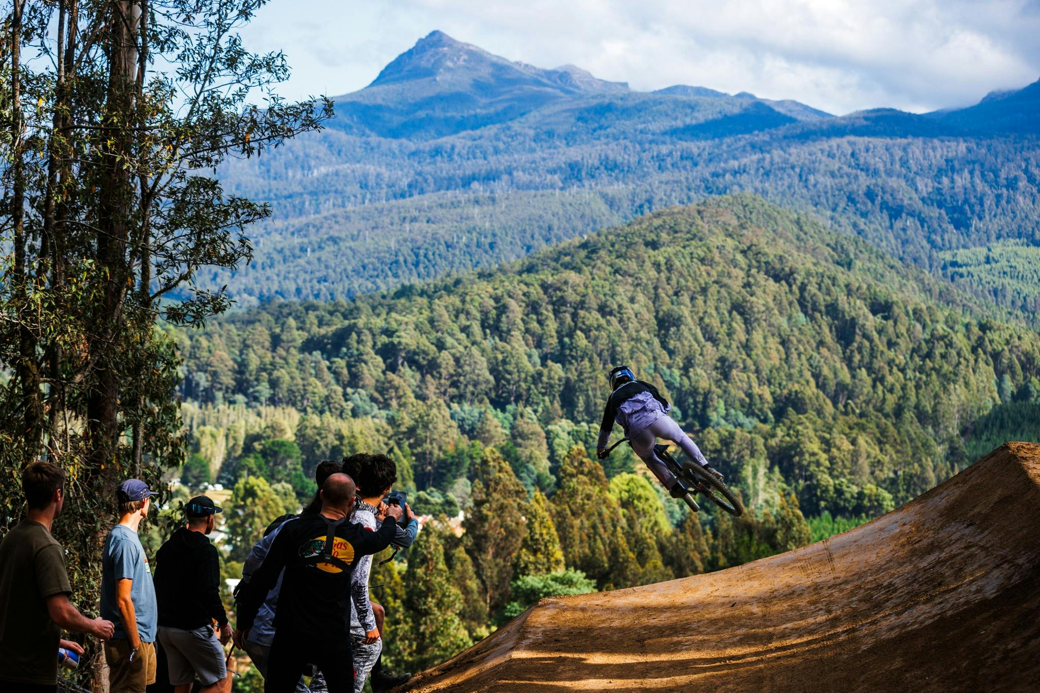 Rider on big gap jump with mountains in background