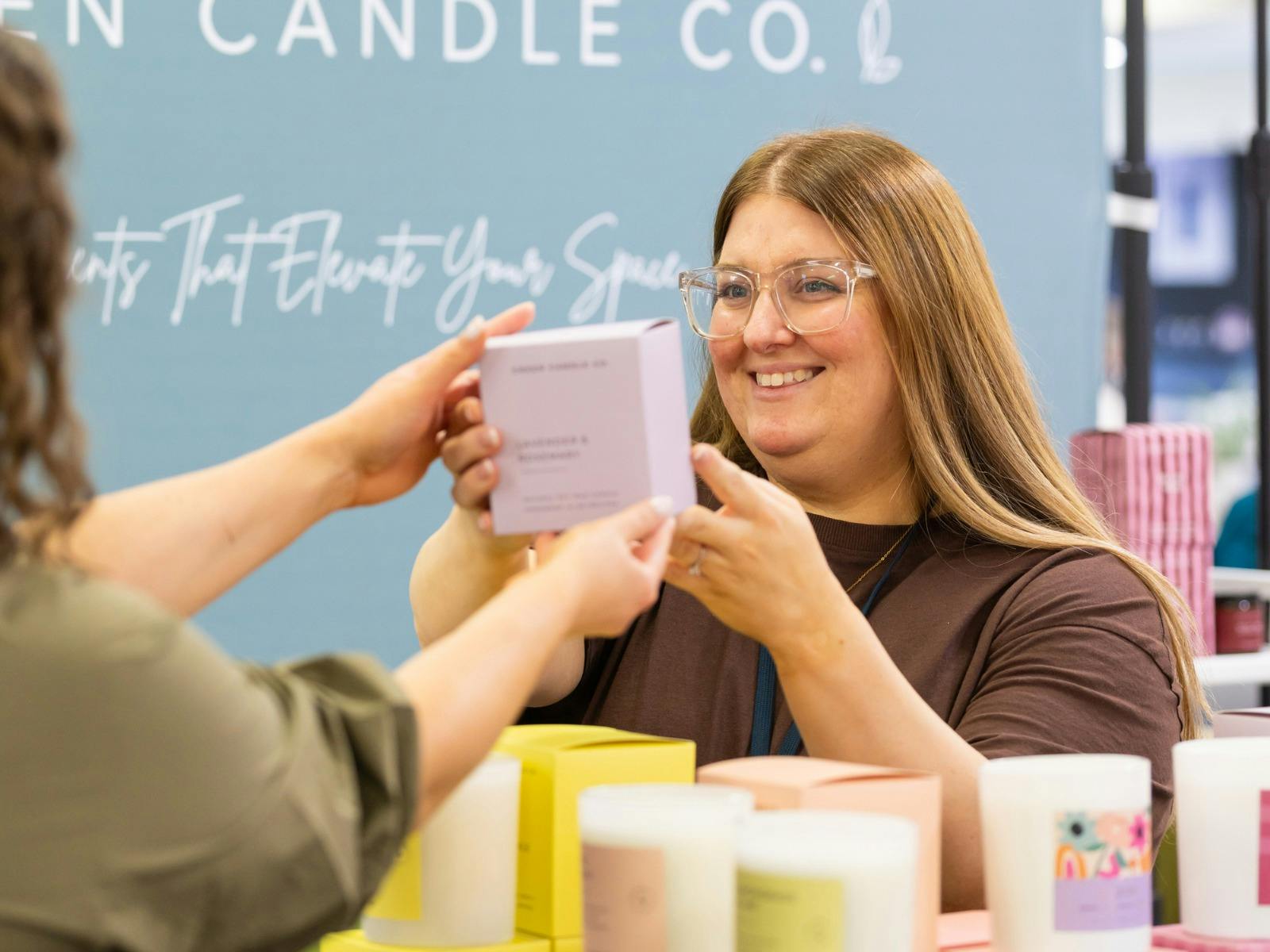 Green Candle Co handing a candle to a customer