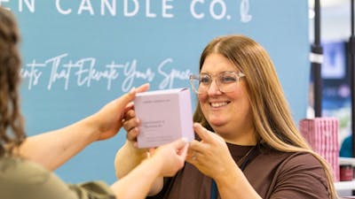 Green Candle Co handing a candle to a customer