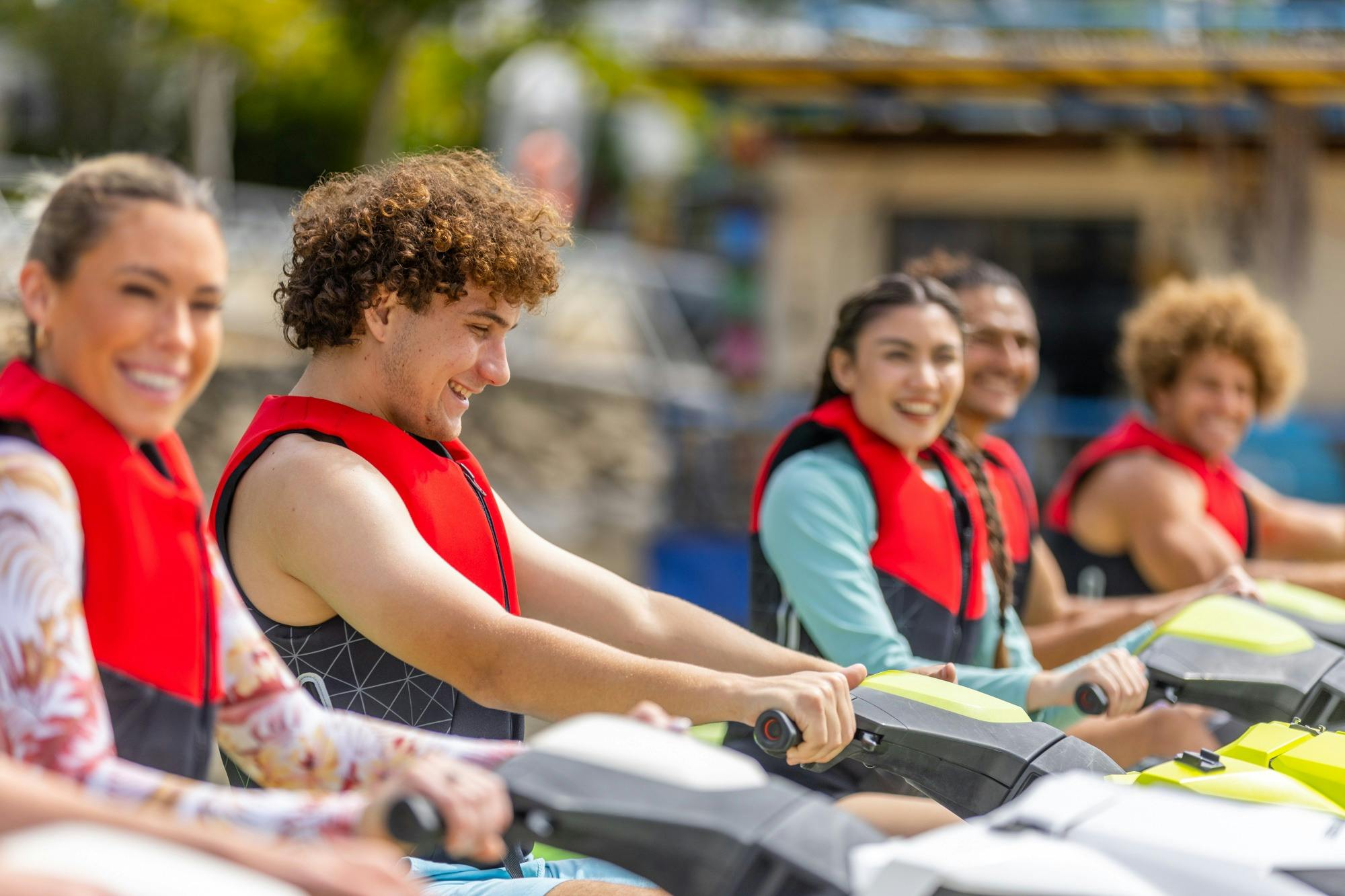 Jetski instructor giving a safety briefing to a group of people wearing life jackets on a dock.
