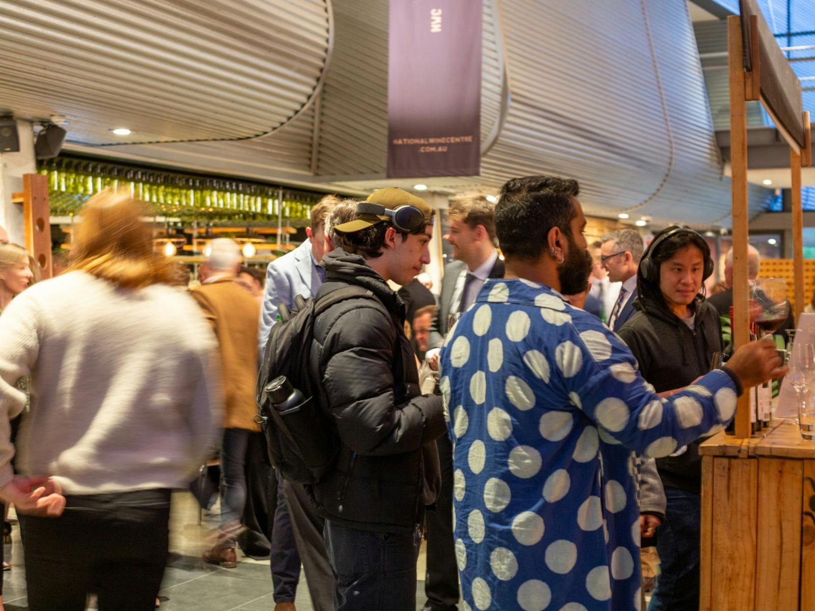 A crowd waiting to taste wines at some wine stands