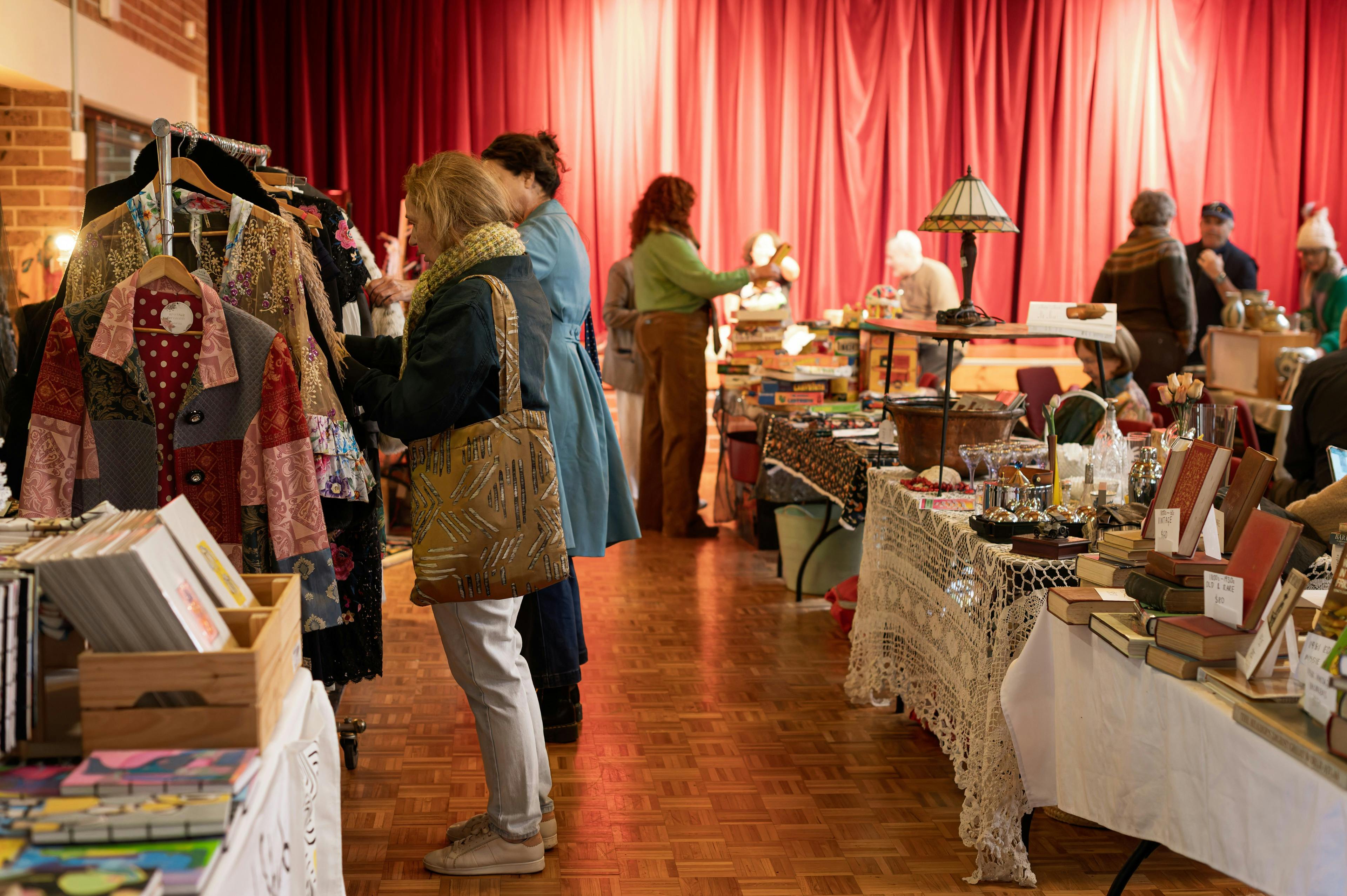 People browsing racks of clothing at a market.