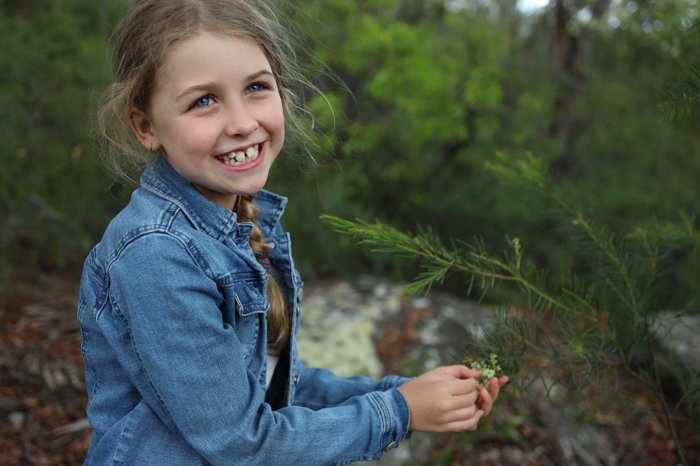 Child holding wattle flower