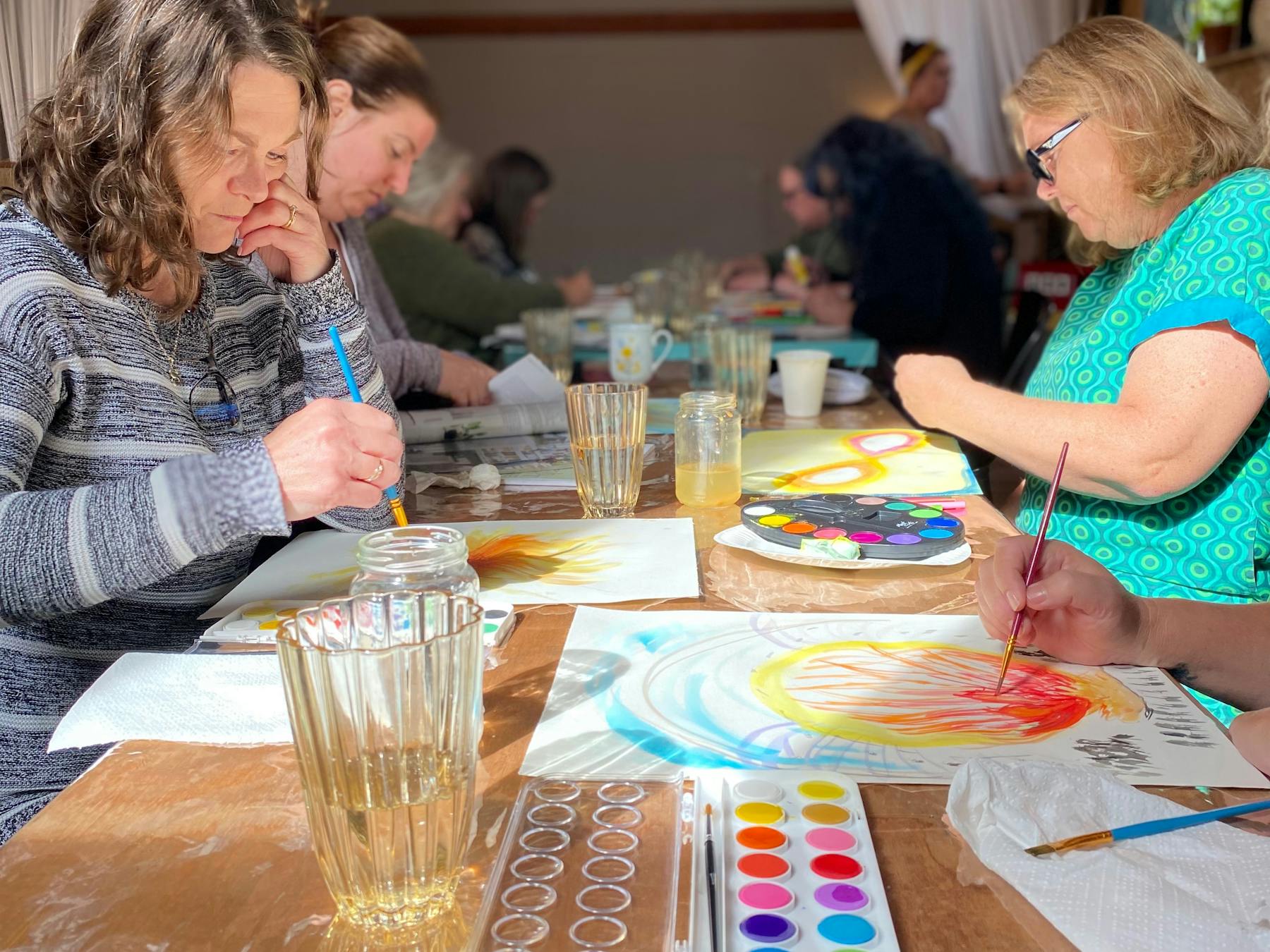 Women painting artwork at a table